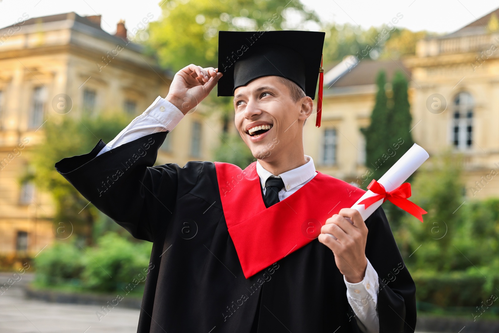 Photo of Happy student with diploma after graduation ceremony outdoors