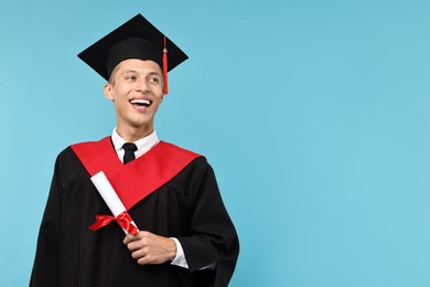 Photo of Happy student with diploma after graduation on light blue background. Space for text