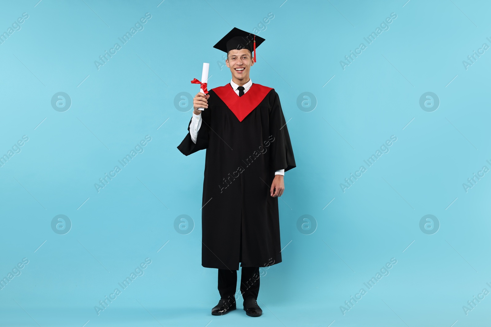 Photo of Happy student with diploma after graduation on light blue background