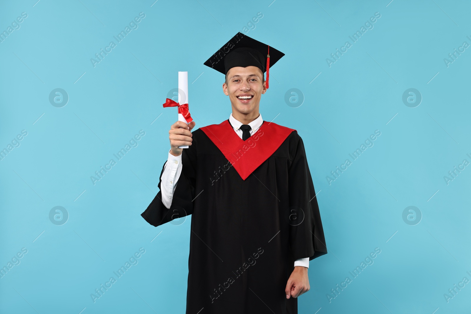 Photo of Happy student with diploma after graduation on light blue background