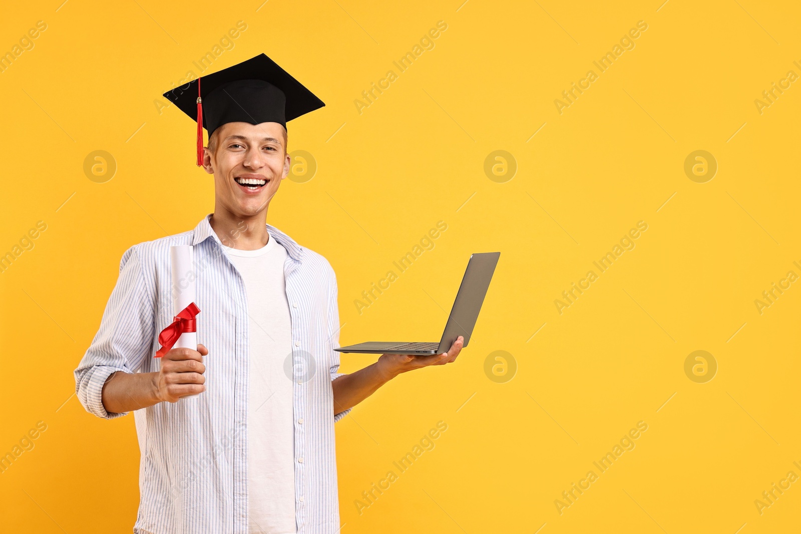 Photo of Happy student with diploma and laptop after graduation on orange background. Space for text