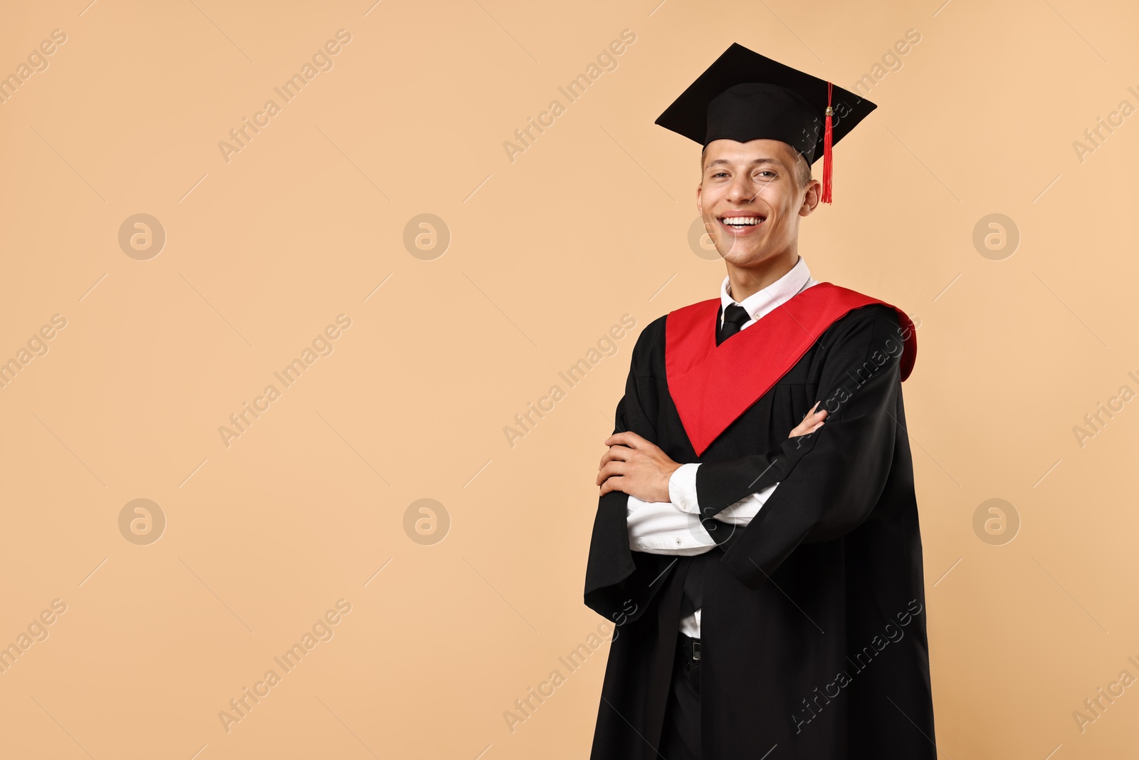 Photo of Happy student with crossed arms after graduation on beige background. Space for text