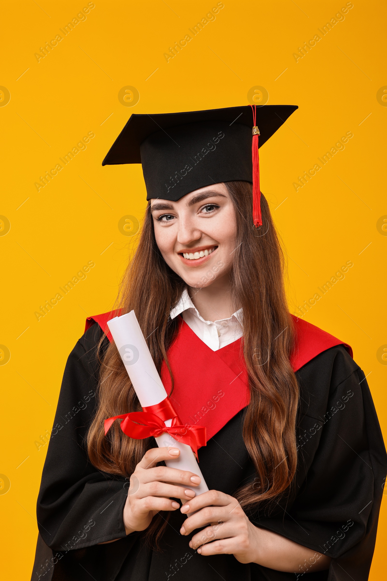 Photo of Happy student with diploma after graduation on orange background