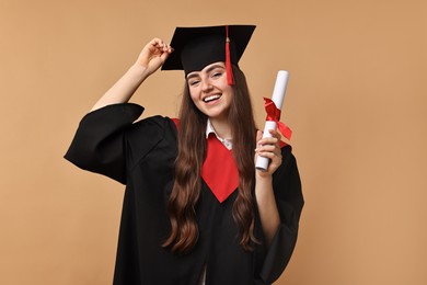 Photo of Happy student with diploma after graduation on beige background