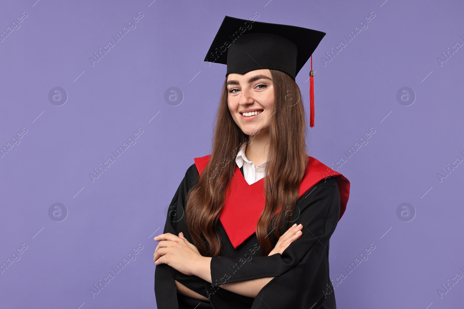 Photo of Happy student with crossed arms after graduation on violet background. Space for text