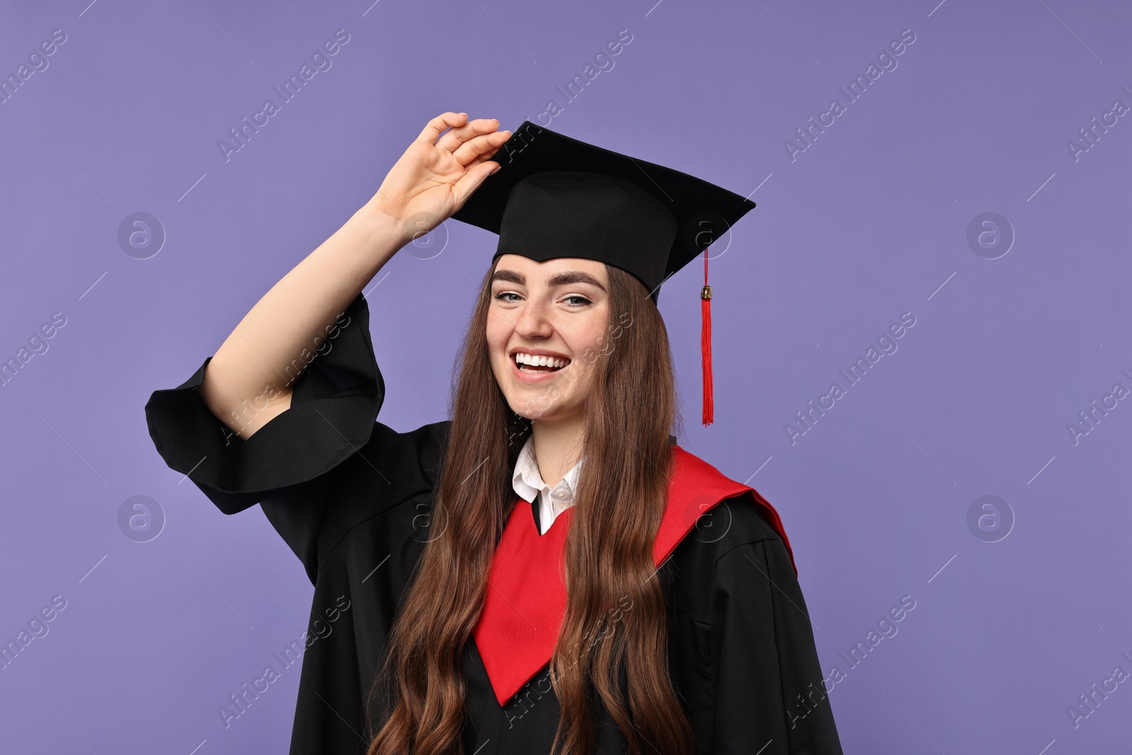 Photo of Happy student after graduation on violet background