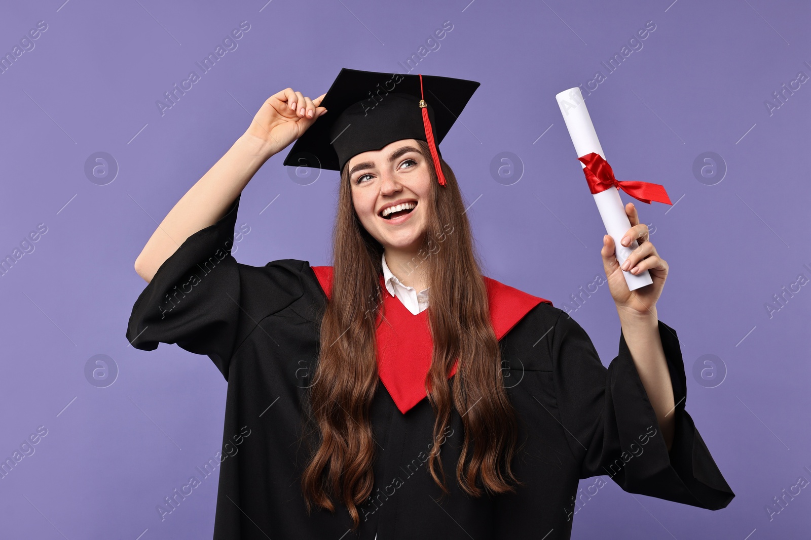 Photo of Happy student with diploma after graduation on violet background