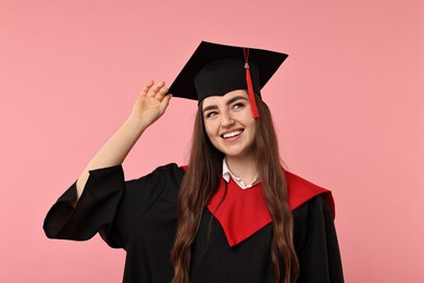 Photo of Happy student after graduation on pink background