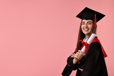 Photo of Happy student with diploma after graduation on pink background. Space for text