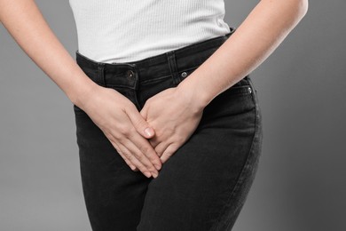 STD (sexually transmitted disease). Woman suffering from symptoms on grey background, closeup