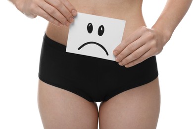 Photo of STD (sexually transmitted disease). Woman holding sticky note with drawn sad face on white background, closeup