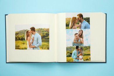 Photo of Open photo album with different photos on light blue background, top view