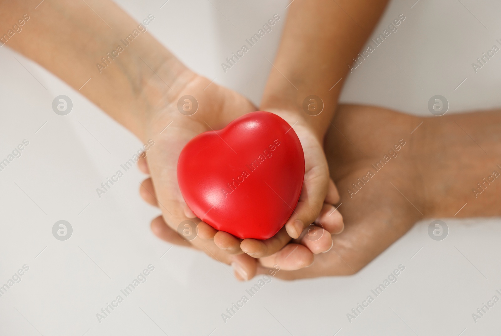 Photo of Little girl and her father with red heart figure on white background, top view