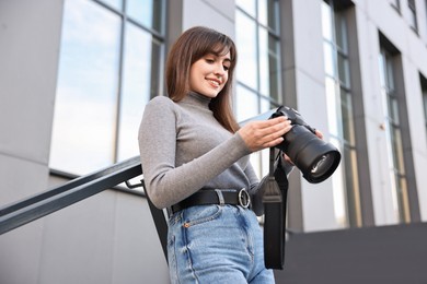 Professional photographer with digital camera outdoors, low angle view