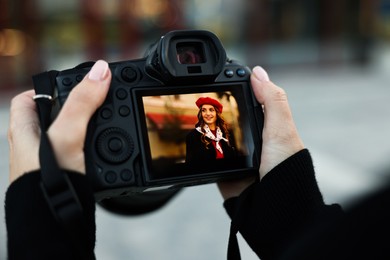 Photo of Professional photographer with digital camera outdoors, closeup