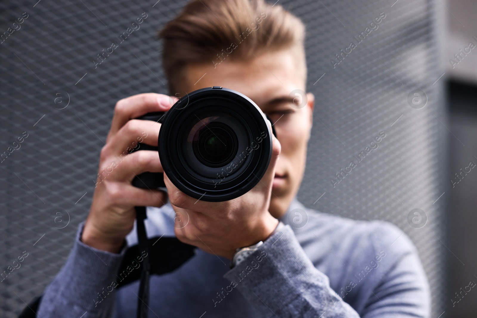 Photo of Professional photographer taking picture with camera outdoors, selective focus