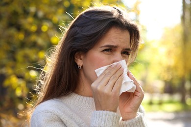 Photo of Young woman with runny nose in park