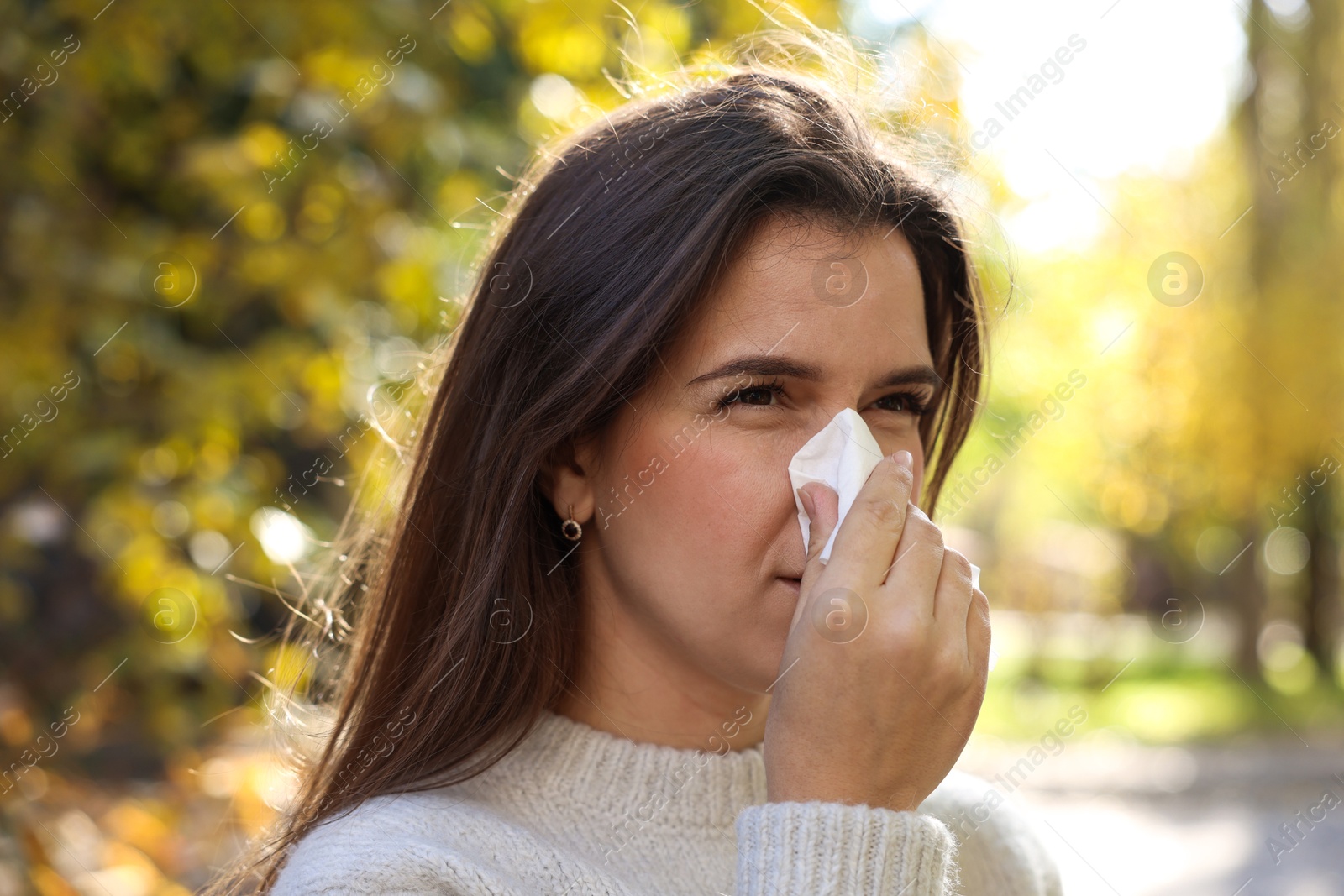 Photo of Young woman with runny nose in park