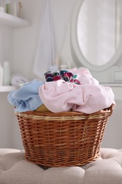 Photo of Laundry detergent and clothes in basket indoors