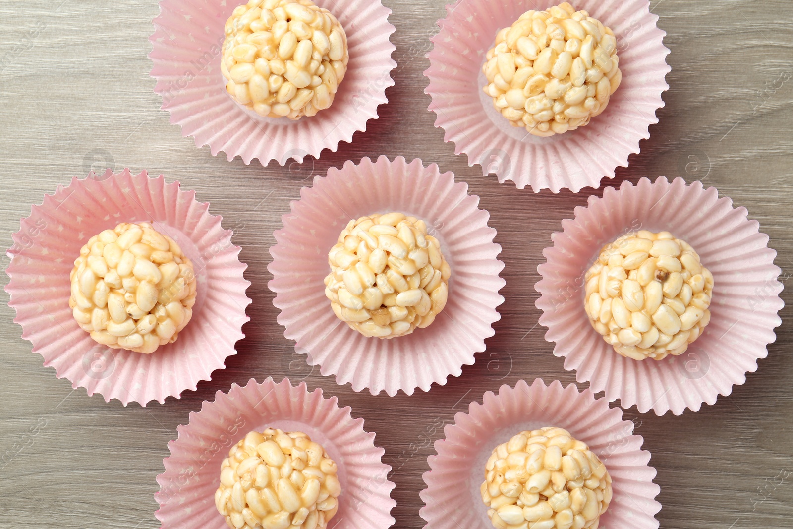 Photo of Tasty puffed rice balls on wooden table, flat lay