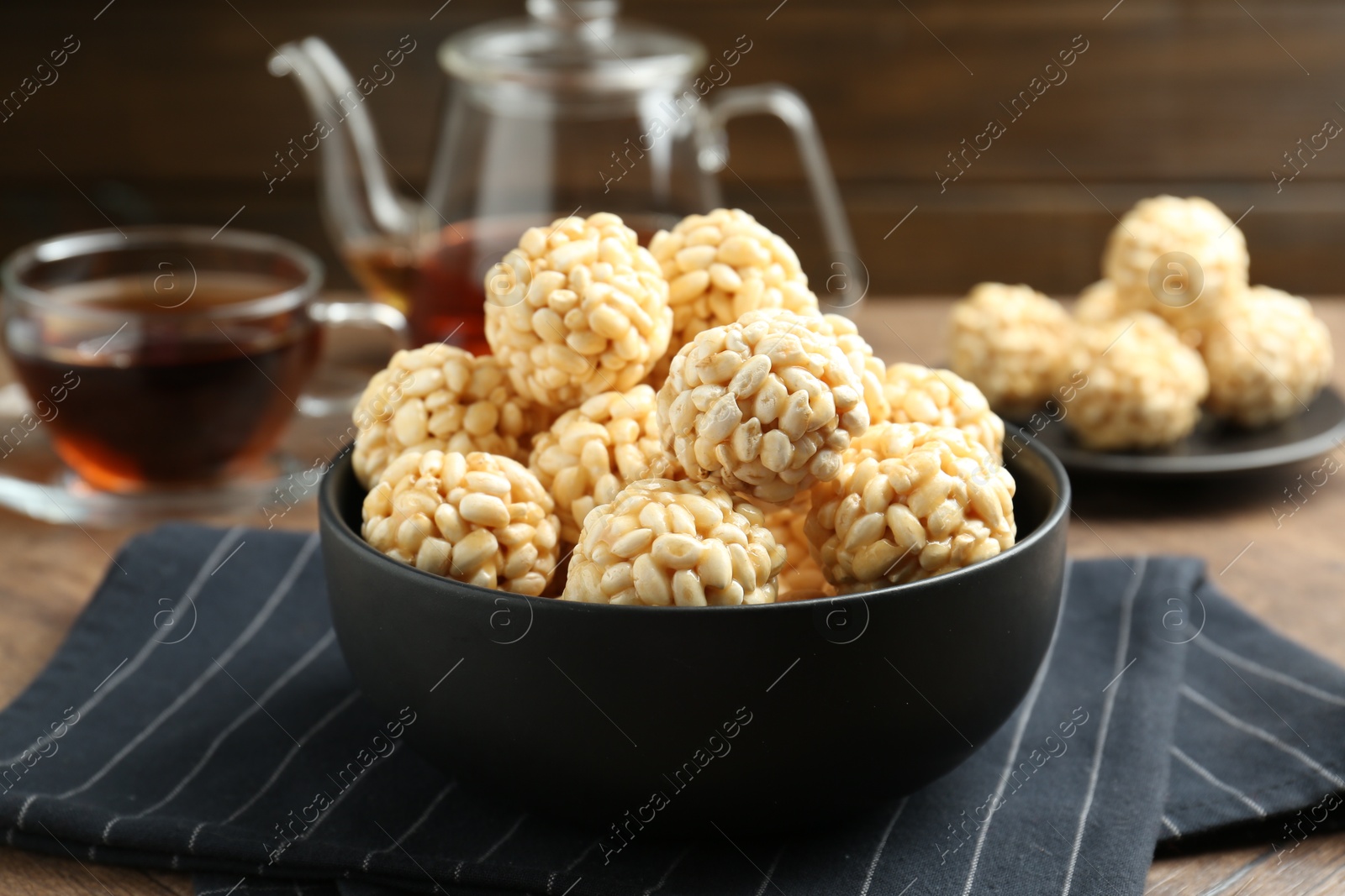 Photo of Tasty puffed rice balls in bowl on table, closeup