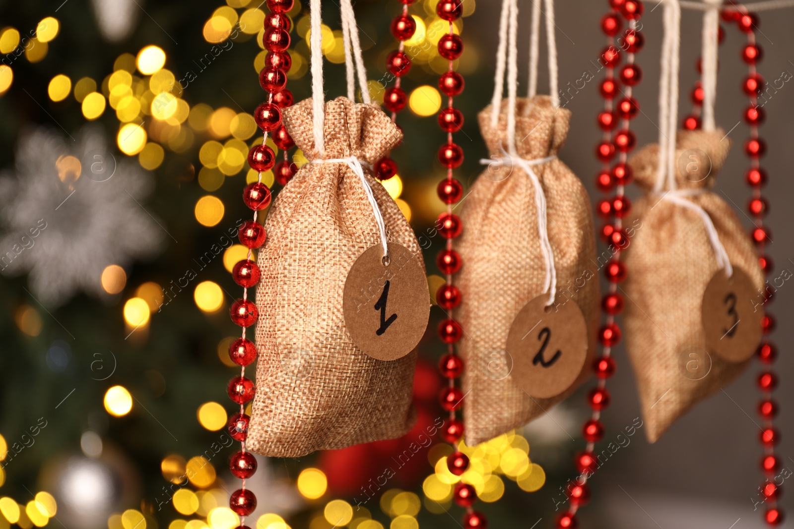 Photo of Christmas advent calendar with gifts and decor hanging indoors, closeup