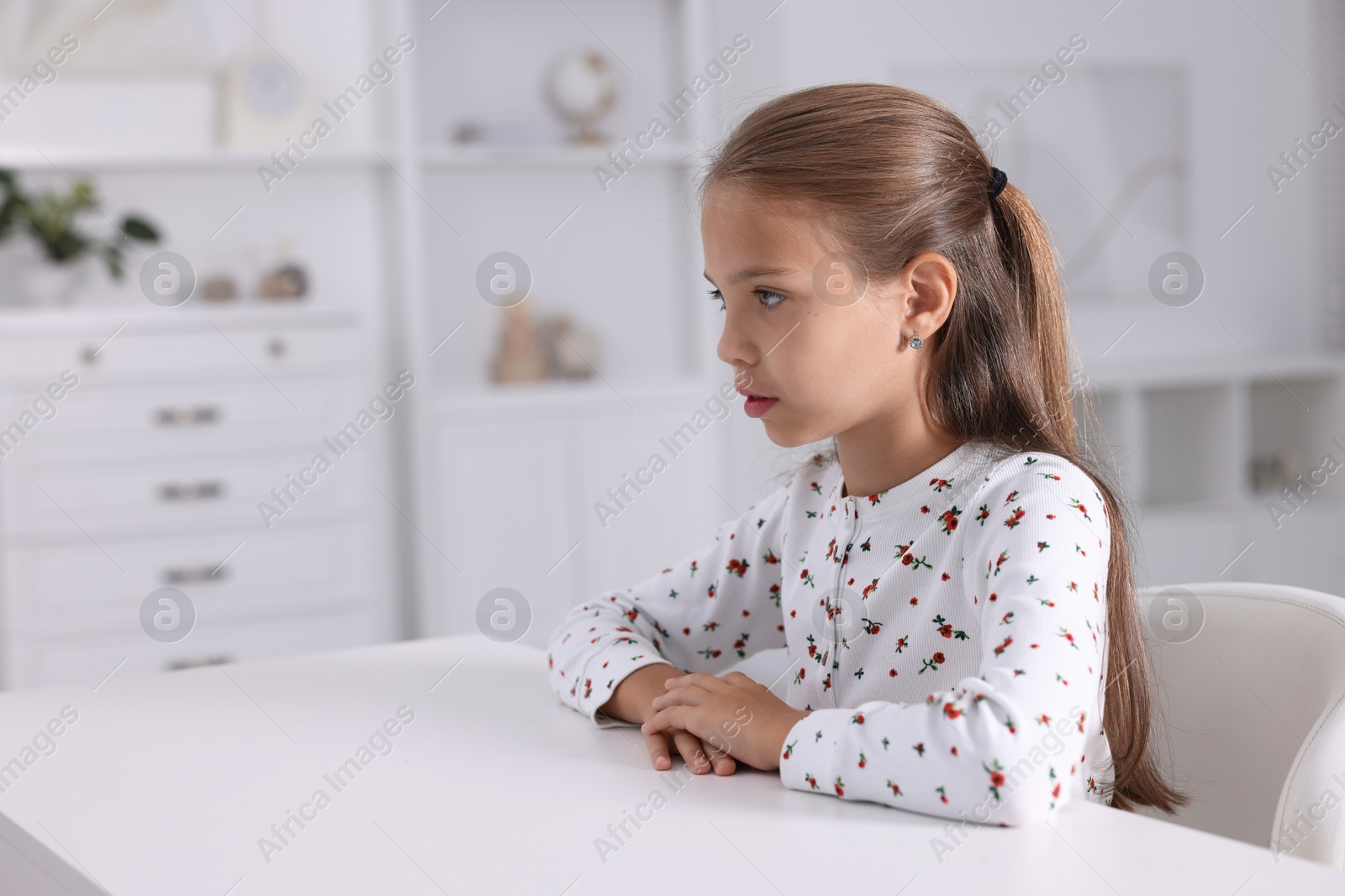 Photo of Girl with correct posture sitting at white desk indoors