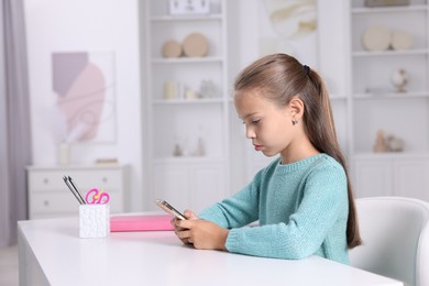 Photo of Girl with correct posture using smartphone at white desk indoors