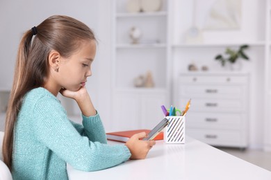 Photo of Girl with correct posture using smartphone at white desk indoors