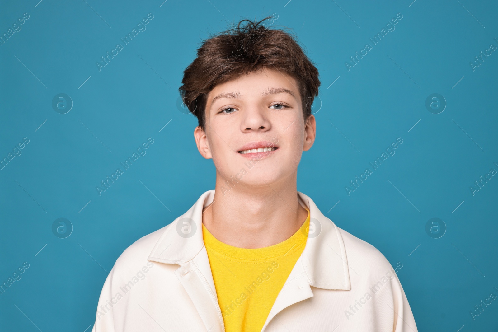 Photo of Portrait of teenage boy on light blue background