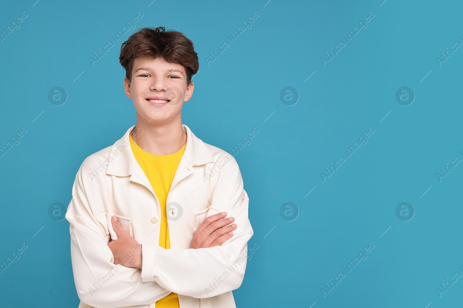 Photo of Portrait of teenage boy on light blue background, space for text