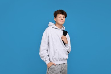 Photo of Teenage boy with backpack on light blue background