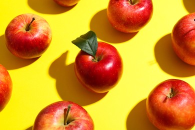 Photo of Many red apples on yellow background, flat lay