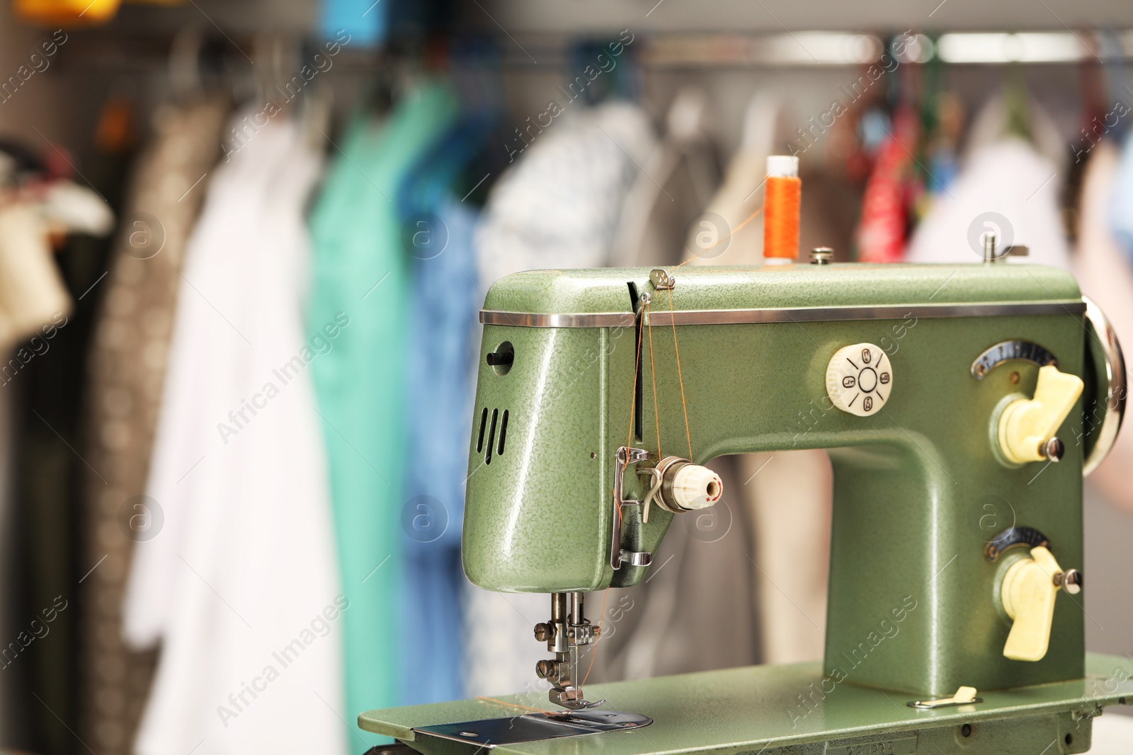 Photo of Vintage sewing machine with thread in workshop