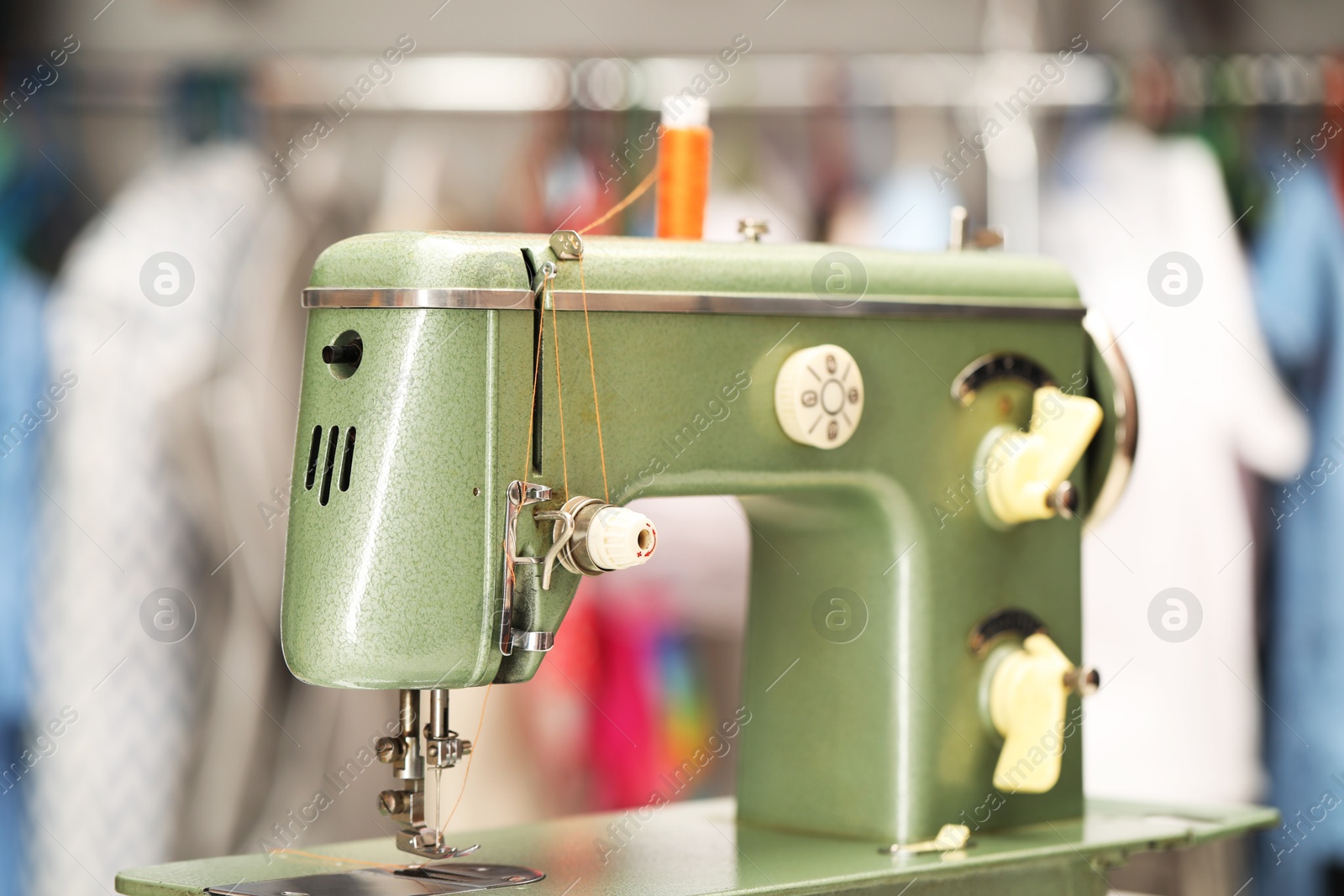 Photo of Vintage sewing machine with thread in workshop, closeup