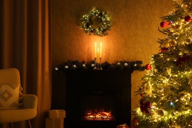 Photo of Cozy room with Christmas tree, fireplace and armchair. Interior design for holiday