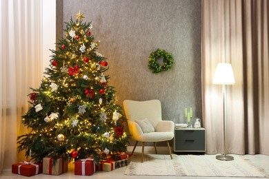 Cozy room with beautiful Christmas tree, armchair and lamp. Interior design for holiday