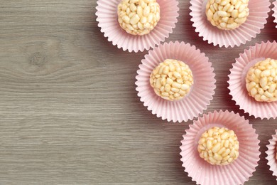 Photo of Tasty puffed rice balls on wooden table, flat lay. Space for text