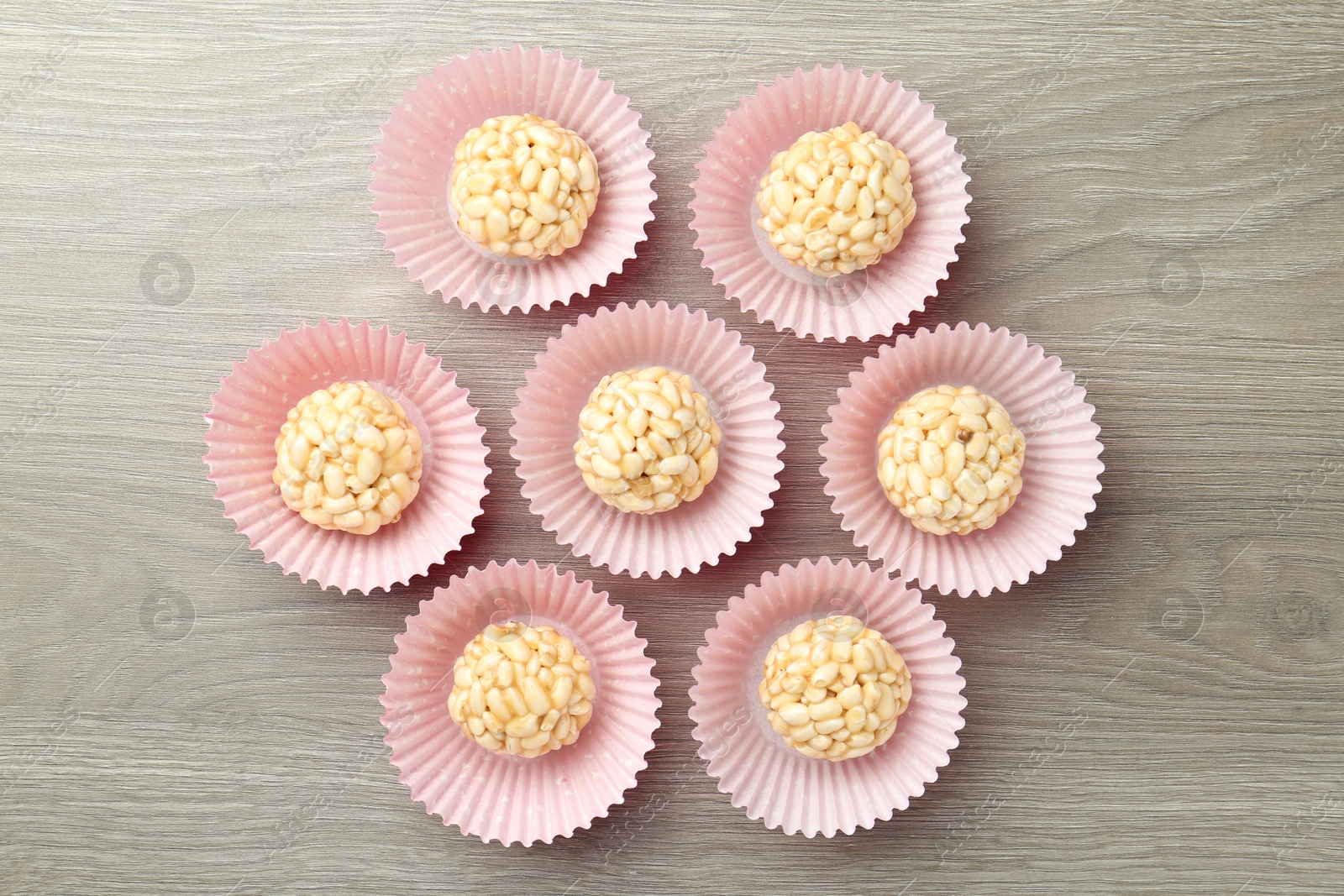 Photo of Tasty puffed rice balls on wooden table, flat lay