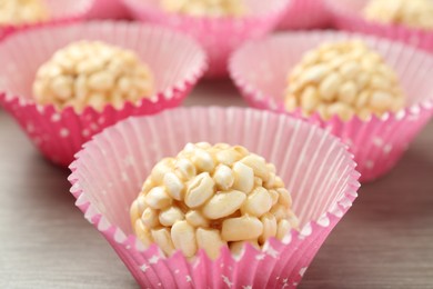 Tasty puffed rice balls on wooden table, closeup