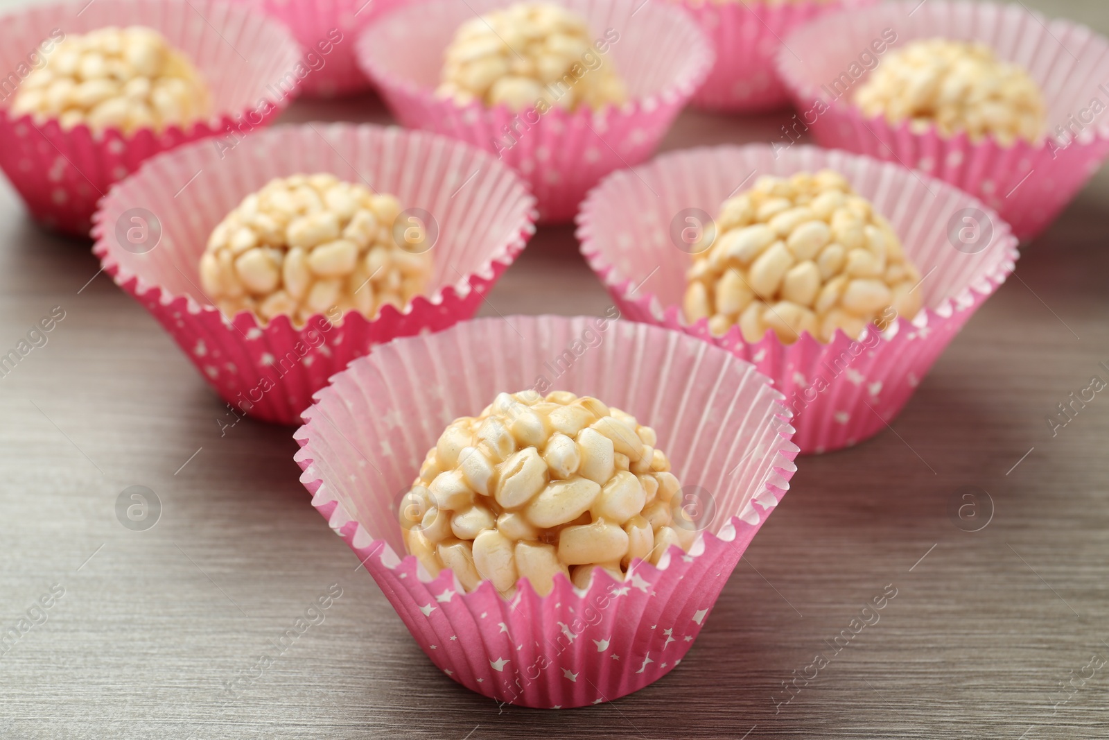 Photo of Tasty puffed rice balls on wooden table, closeup