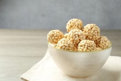 Photo of Tasty puffed rice balls in bowl on table, closeup