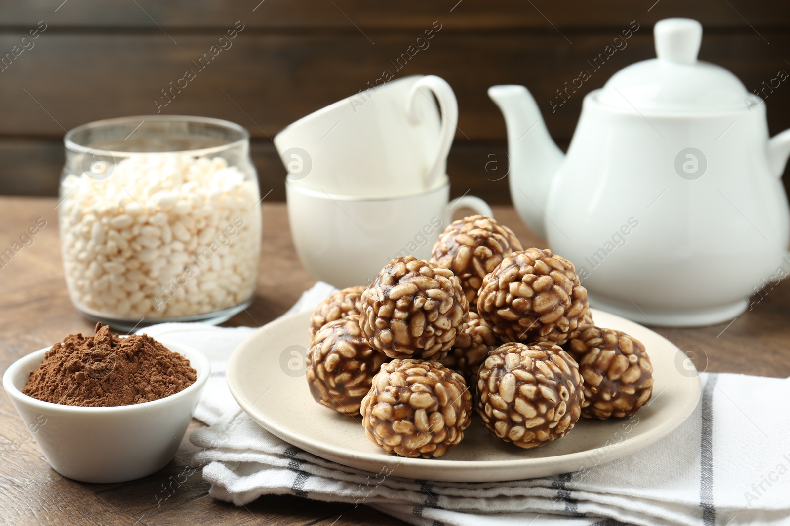 Photo of Tasty chocolate puffed rice balls served on wooden table