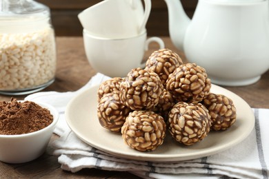 Tasty chocolate puffed rice balls served on wooden table, closeup