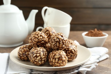 Tasty chocolate puffed rice balls served on wooden table, closeup