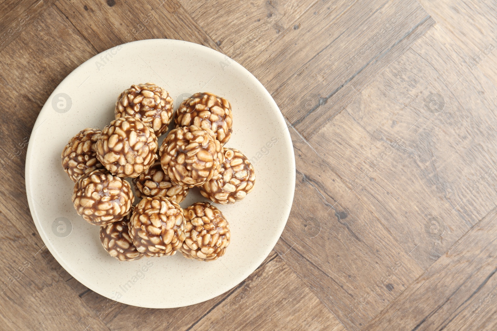 Photo of Tasty chocolate puffed rice balls on wooden table, top view. Space for text