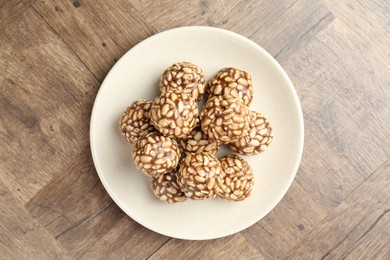 Photo of Tasty chocolate puffed rice balls on wooden table, top view