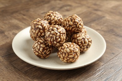 Tasty chocolate puffed rice balls on wooden table, closeup