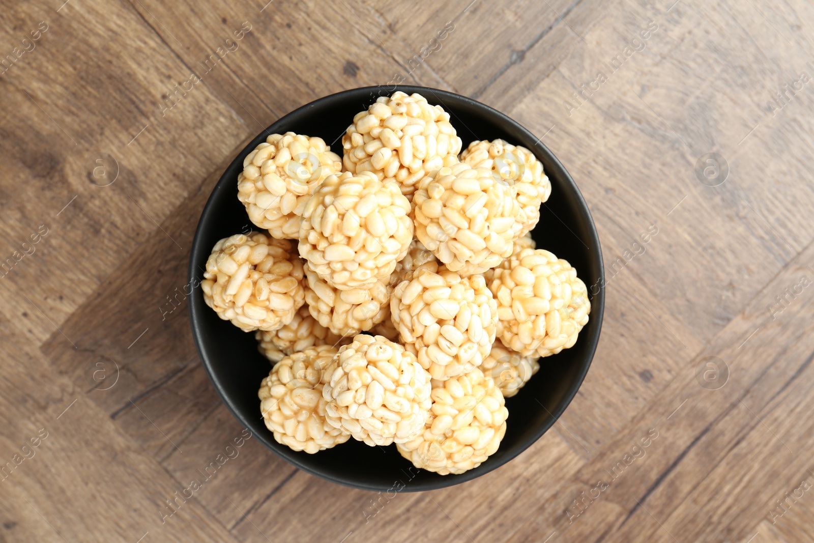 Photo of Tasty puffed rice balls on wooden table, top view