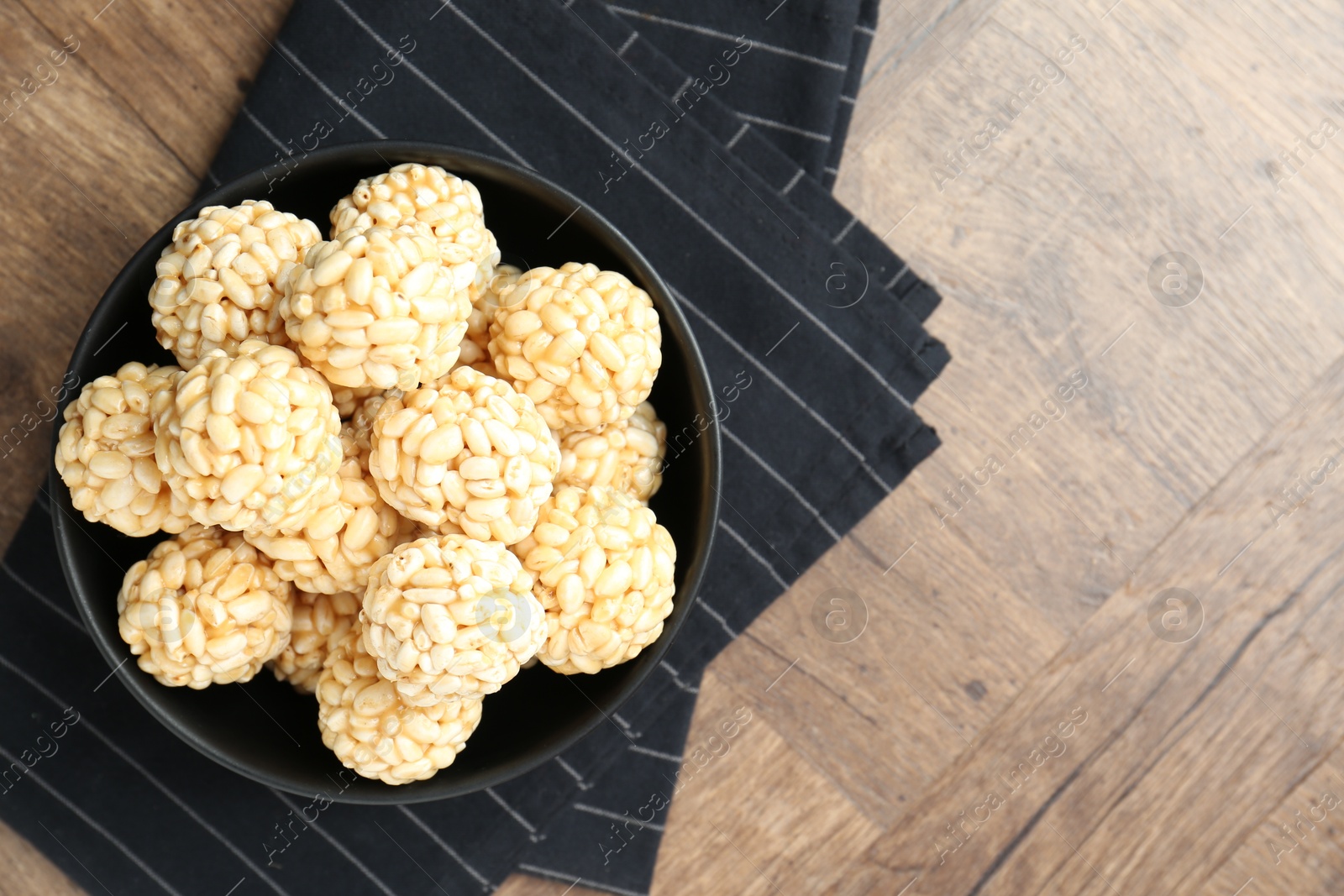 Photo of Tasty puffed rice balls on wooden table, top view. Space for text